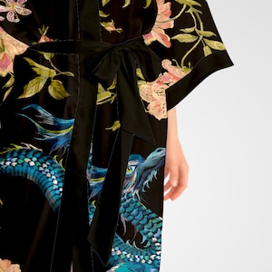 May include: Black silk robe with a floral and dragon print. The robe has a tie belt and long sleeves.