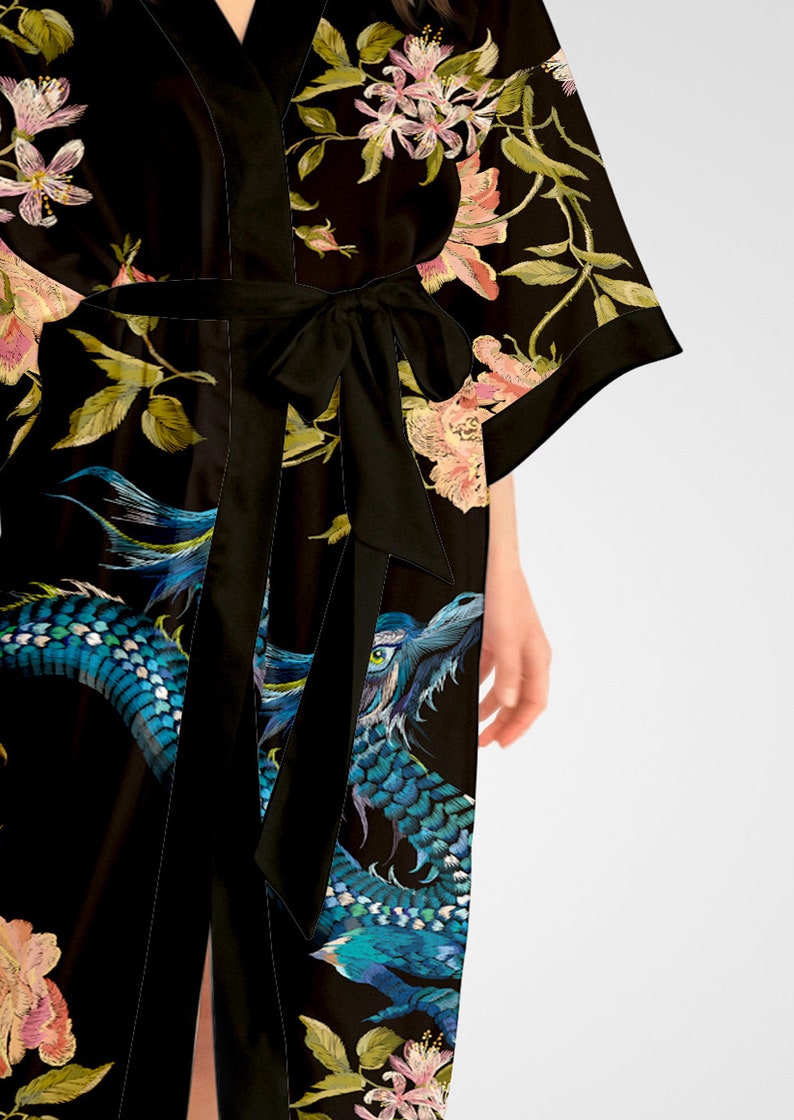 May include: Black silk robe with a floral and dragon print. The robe has a tie belt and long sleeves.