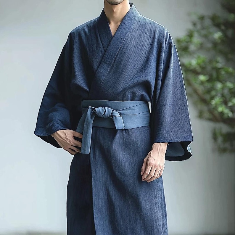 May include: A dark blue cotton yukata with a matching dark blue sash tied at the waist. The yukata has a traditional Japanese design and is made of a lightweight fabric.