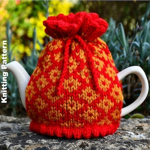 Könnte beinhalten: Ein rot-goldener Strick-Teewärmer mit Kordelzug. Der Teewärmer ist mit einem sich wiederholenden geometrischen Muster versehen und wird über einer weißen Teekanne platziert. Der Text "Knitting Pattern" ist auf der linken Seite des Bildes zu sehen.