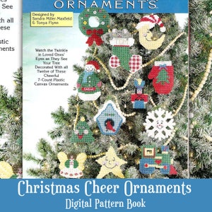May include: A Christmas tree decorated with 12 colorful plastic canvas ornaments. The ornaments feature a variety of holiday themes, including a snowman, a birdhouse, a stocking, a star, a train, a snowflake, a mitten, a nutcracker, a moon, a wreath, a mouse, and a tree. The text "Christmas Cheer Ornaments Digital Pattern Book" is at the bottom of the image.