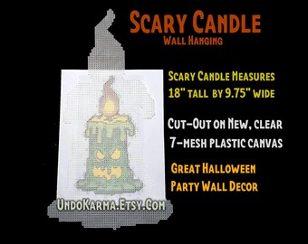 May include: A Scary Candle wall hanging made of clear 7-mesh plastic canvas. The design features a green candle with a yellow flame and a carved face. It measures 18 inches tall by 9.75 inches wide. The text reads Scary Candle Wall Hanging.
