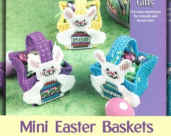 May include: Three plastic canvas Easter baskets with bunny designs. The baskets are purple, yellow, and blue. Each basket has a white bunny with a colorful egg inside. The baskets are filled with colorful candy eggs. The image includes the text "Heartfelt Gifts" and "Mini Easter Baskets Plastic Canvas Digital Pattern".