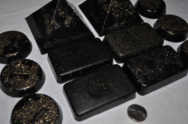May include: A collection of black, rectangular, and pyramid-shaped objects with a glittery, textured surface.