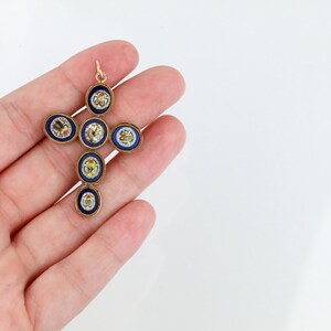 May include: A gold cross pendant with blue enamel and colourful mosaic details. The cross is made up of seven round pieces, each with a different design.
