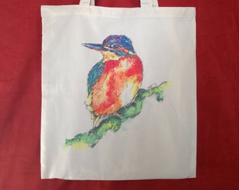 Könnte beinhalten: Eine weiße Einkaufstasche mit einem farbenfrohen Aquarellbild eines Eisvogels, der auf einem Ast sitzt. Der Vogel ist in Blautönen, Grün, Orange und Rot gemalt.