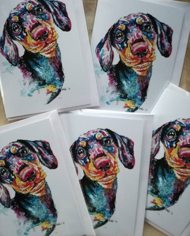 Op de afbeelding: Vijf blanco wenskaarten met kleurrijke aquarel illustraties van een teckel. De hond kijkt recht naar de kijker met een speelse uitdrukking. De kaarten zijn perfect om een speciale boodschap naar een geliefde te sturen.