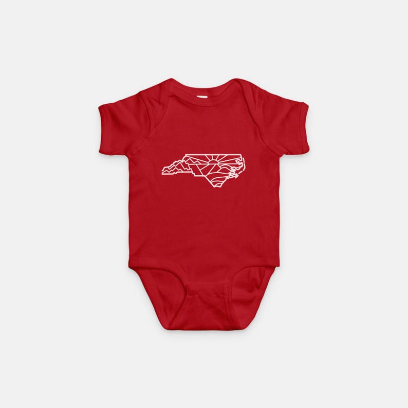 May include: Red baby onesie with a white outline of the state of North Carolina. The outline includes mountains and a sun.