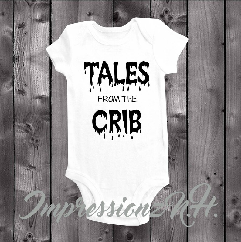 May include: White baby onesie with black dripping text that reads "Tales from the Crib".