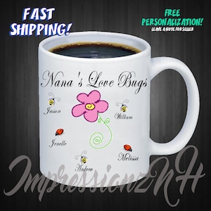 May include: White ceramic mug with the text "Nana's Love Bugs" and personalized names. Features a pink flower and cartoon bees and ladybugs. The mug is filled with coffee and has the text "Fast Shipping!" and "Free Personalization!"