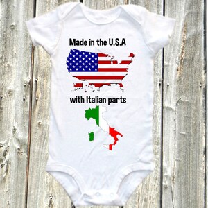 May include: White baby onesie with a graphic of the United States of America with the American flag and the text "Made in the U.S.A with Italian parts" and a graphic of Italy with the Italian flag.