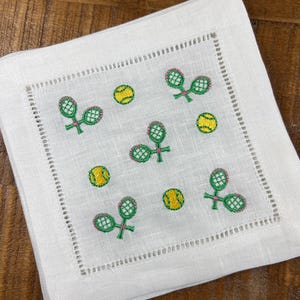 Servilletas de cóctel bordadas con raquetas de tenis dispersas