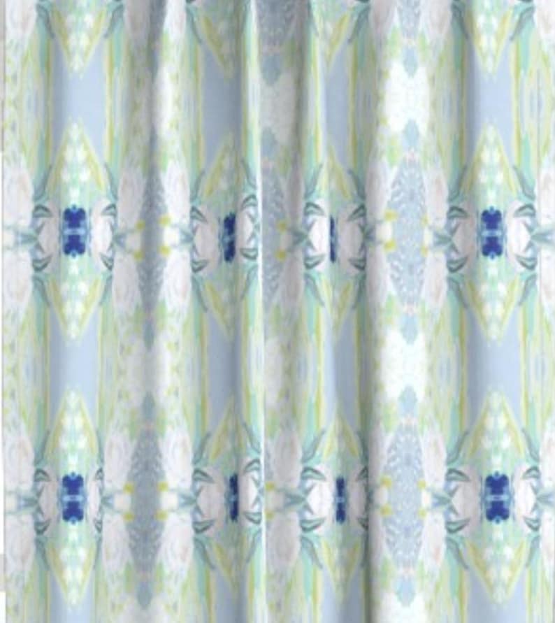 May include: A shower curtain with a light blue background and a white, green, and blue geometric pattern.