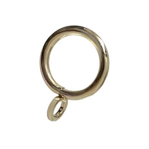 May include: Gold curtain ring with a smaller ring attached. The ring is designed to hold curtains or drapes.