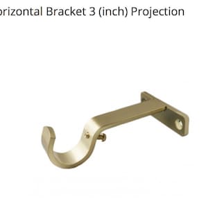 May include: Gold metal curtain rod bracket with a 3 inch projection. The bracket has a curved arm and a flat rectangular base.