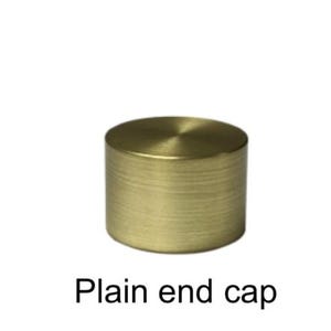 Pu&ograve; includere: Un tappo terminale cilindrico in ottone dorato con una parte superiore piatta e un corpo strutturato e scanalato. Il tappo &egrave; di colore oro caldo ed &egrave; posto su uno sfondo bianco. Il testo "Plain end cap" &egrave; sotto.