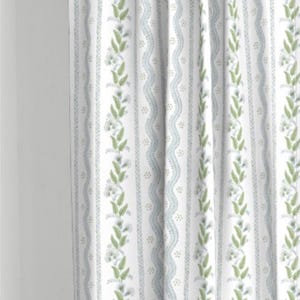 May include: White curtains with a repeating pattern of green leaves, blue wavy lines, and small white dots.