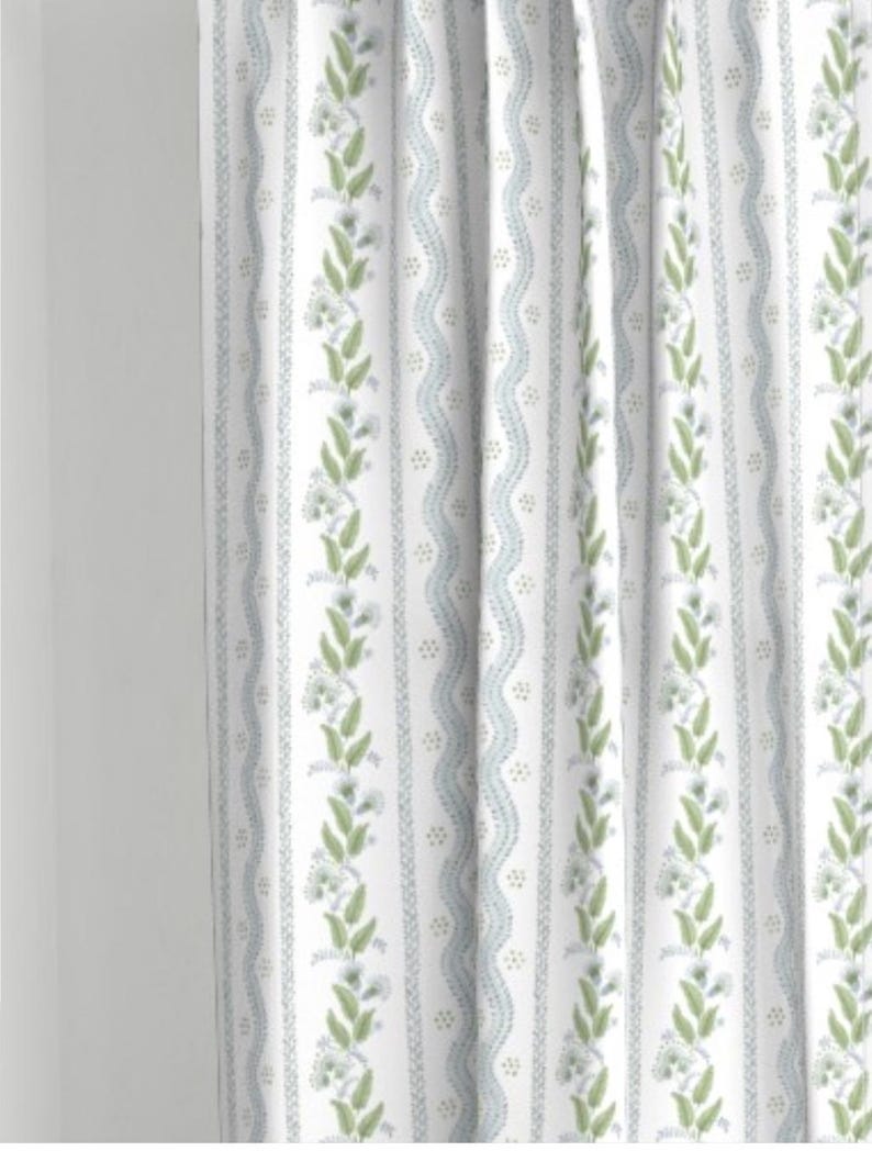 May include: White curtains with a repeating pattern of green leaves, blue wavy lines, and small white dots.