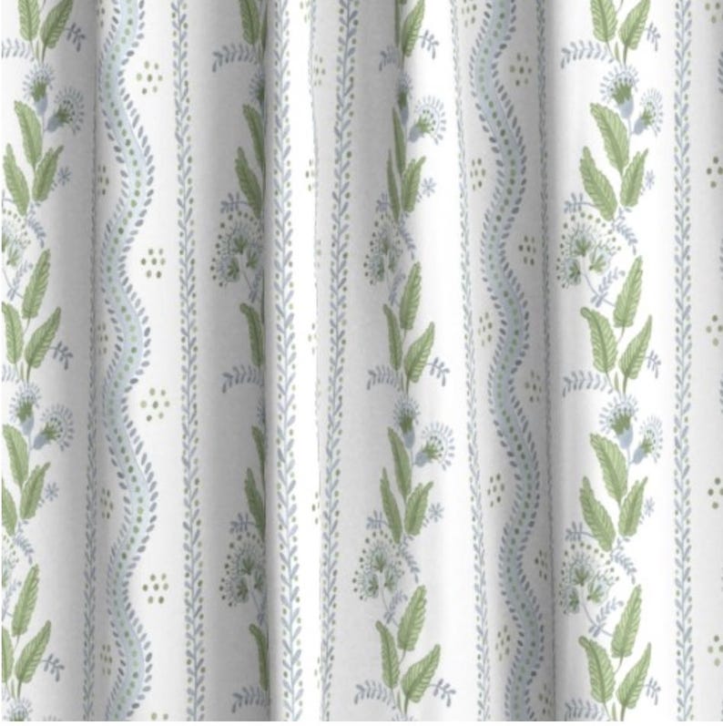 May include: White fabric with a repeating pattern of green and blue floral sprigs. The pattern is vertical and includes small dots.