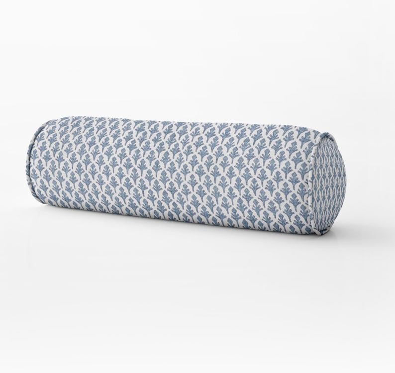 May include: A blue and white patterned bolster pillow. The pillow is cylindrical and has a white background with a repeating blue floral pattern.