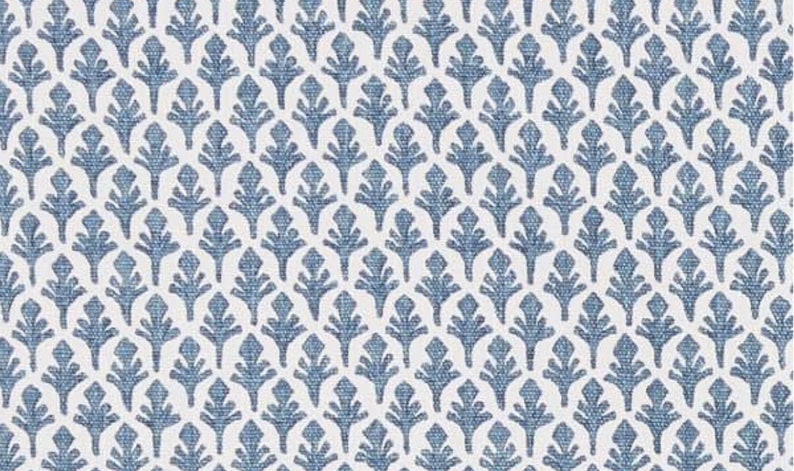 May include: A white fabric with a repeating pattern of blue stylised floral designs.