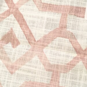 May include: Close-up of a white fabric with a geometric pattern in a soft pink hue. The design features intersecting lines and shapes, creating a textured appearance. The fabric has a slightly sheer quality, suggesting it might be used for clothing or home decor.