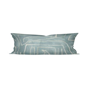 May include: A rectangular decorative pillow with a light blue background and a white, abstract, linear pattern. The pillow is a long, bolster style, and is likely for a bed or sofa.