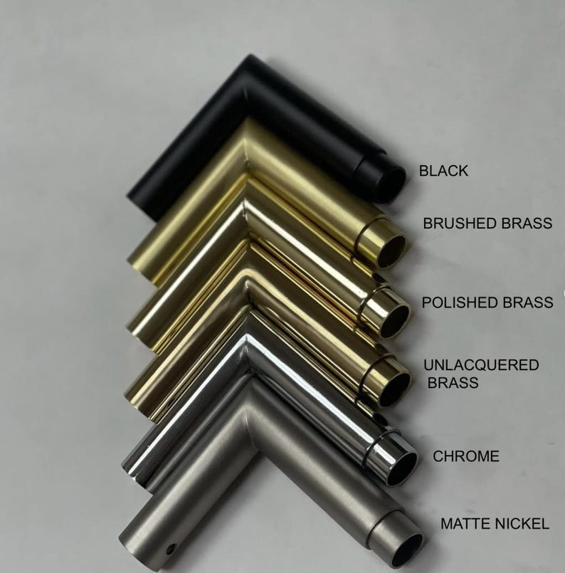 Pu&ograve; includere: Campioni di telai metallici angolari in varie finiture: nero, ottone spazzolato, ottone lucido, ottone non verniciato, cromo e nichel opaco. Ogni campione &egrave; etichettato con il suo nome di finitura. I telai sono disposti in pila diagonale.