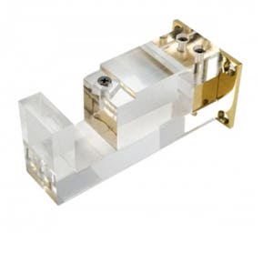 May include: A clear acrylic and gold-toned metal curtain rod bracket. The bracket has a rectangular shape with a clear acrylic base and a gold-toned metal mounting plate. The bracket is designed to hold a curtain rod.