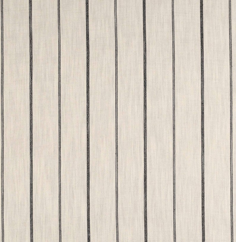 May include: A close-up of a white fabric with thin black stripes. The fabric has a subtle texture.