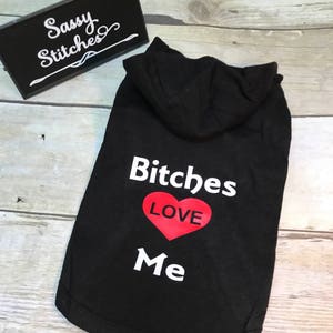 May include: Black hooded dog shirt with the text "Bitches Love Me" and a red heart with the word "LOVE" inside.