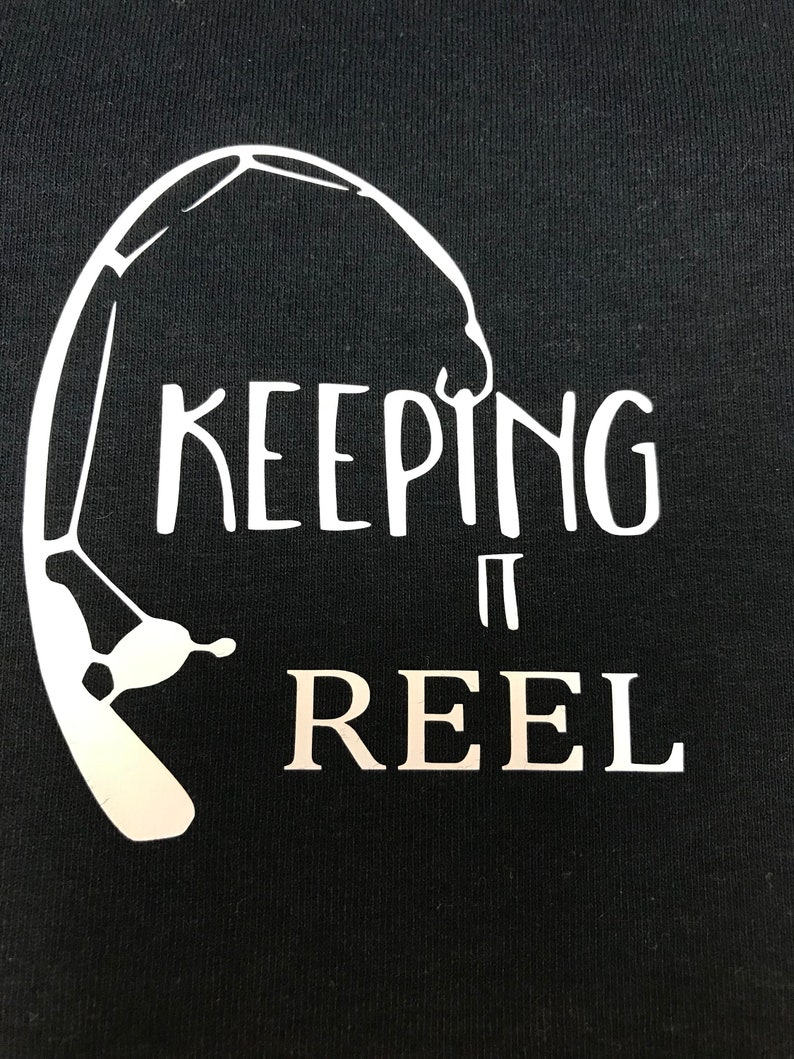 May include: Black t-shirt with a white graphic of a fishing rod and the text "KEEPING IT REEL".