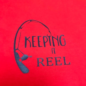 May include: Red t-shirt with a black graphic of a fishing rod and the text "KEEPING IT REEL".