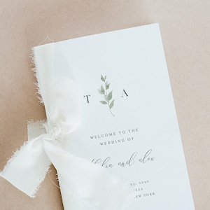 Może przedstawiać: Biały program ślubny z zielonym wzorem gałązki z liśćmi i tekstem "Witamy na ślubie Lii i Alexa" po którym następuje data, miejsce i miasto.