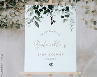 May include: A white welcome sign with a green leafy border. The sign reads "Welcome to Gabrielle's Baby Shower 9.12.20XX".