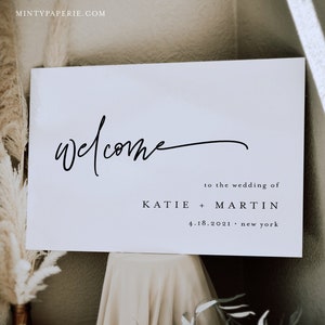 May include: White welcome sign with black calligraphy text that reads "welcome" to the wedding of Katie + Martin 4.18.2021. new york.