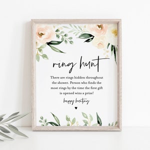 Pu&ograve; includere: Un cartello stampabile con un bordo floreale e il testo "ring hunt". Il cartello dice "There are rings hidden throughout the shower. Person who finds the most rings by the time the first gift is opened wins a prize! happy hunting".