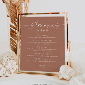 May include: A printable s'mores menu with a brown background and white text. The menu lists different s'mores variations with ingredients, including "The Classic", "The Salted Caramel", "The Samoa", "The Nutty Buddy", and "The Grasshopper".