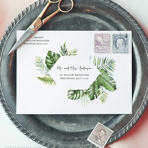 May include: A white envelope with a tropical leaf design and a hexagonal address label. The address label reads "Mr. and Mrs. Anderson, 501 Willow Boulevard, Westwood, NJ 07640".