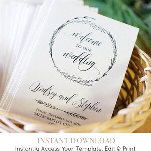 May include: A white wedding programme with a black floral wreath and the text "Welcome to our wedding" and "Lindsey and Stephen". The programme also includes the date and location of the wedding.