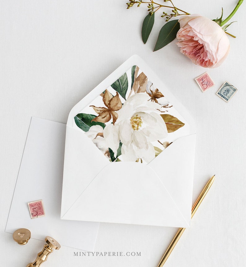 May include: White envelope with a floral liner featuring a white magnolia flower with brown and green leaves. The liner is visible through the flap of the envelope.