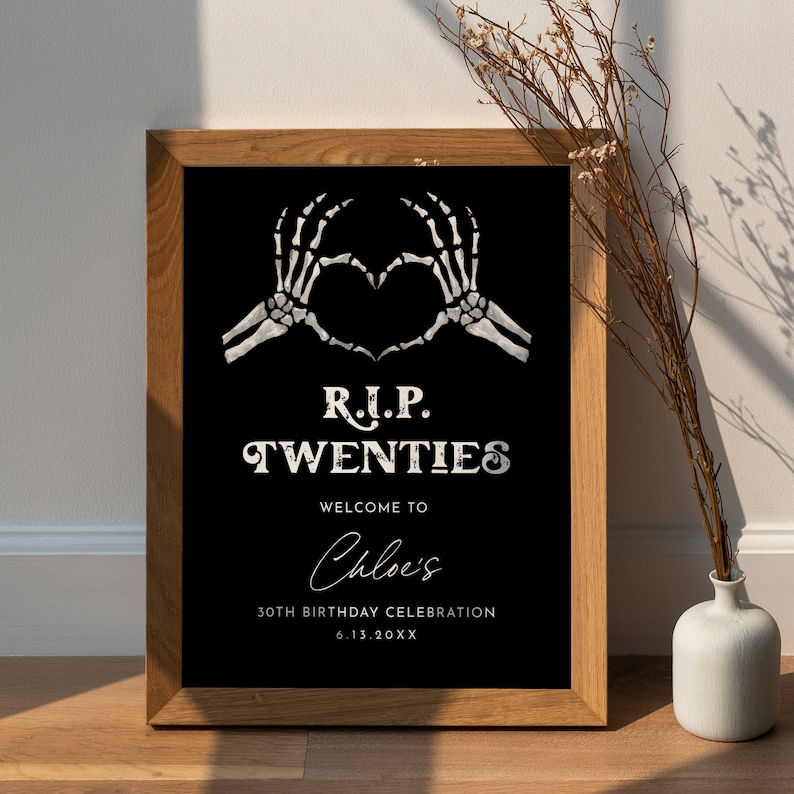May include: A black and white sign with a skeleton hand making a heart shape. The sign reads "R.I.P. TWENTIES Welcome to Chloe's 30th Birthday Celebration 6.13.20XX".