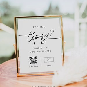 May include: A gold-framed sign with white background and black text that reads "Feeling tipsy? Kindly tip your bartender."  The sign also includes a QR code with the text "Scan Here" and a dollar bill icon with the text "Cash".