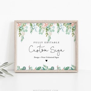 May include: A framed sign with a floral design. The sign has a white background with the words "FULLY EDITABLE Custom Sign" in black script. The frame is light brown. Floral elements include pink and green leaves.