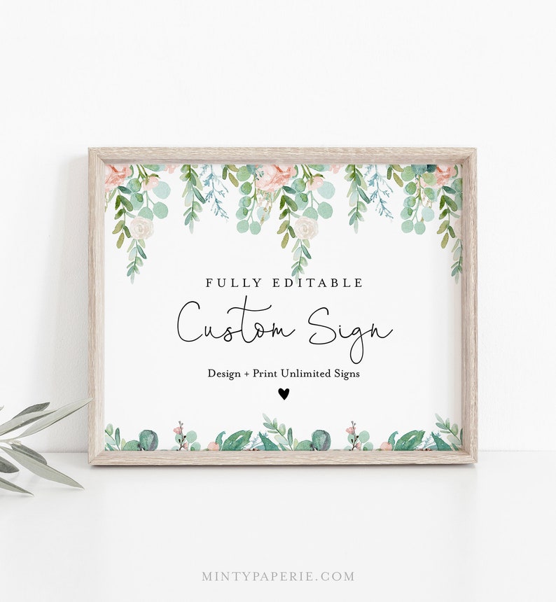 May include: A framed sign with a floral design. The sign has a white background with the words "FULLY EDITABLE Custom Sign" in black script. The frame is light brown. Floral elements include pink and green leaves.