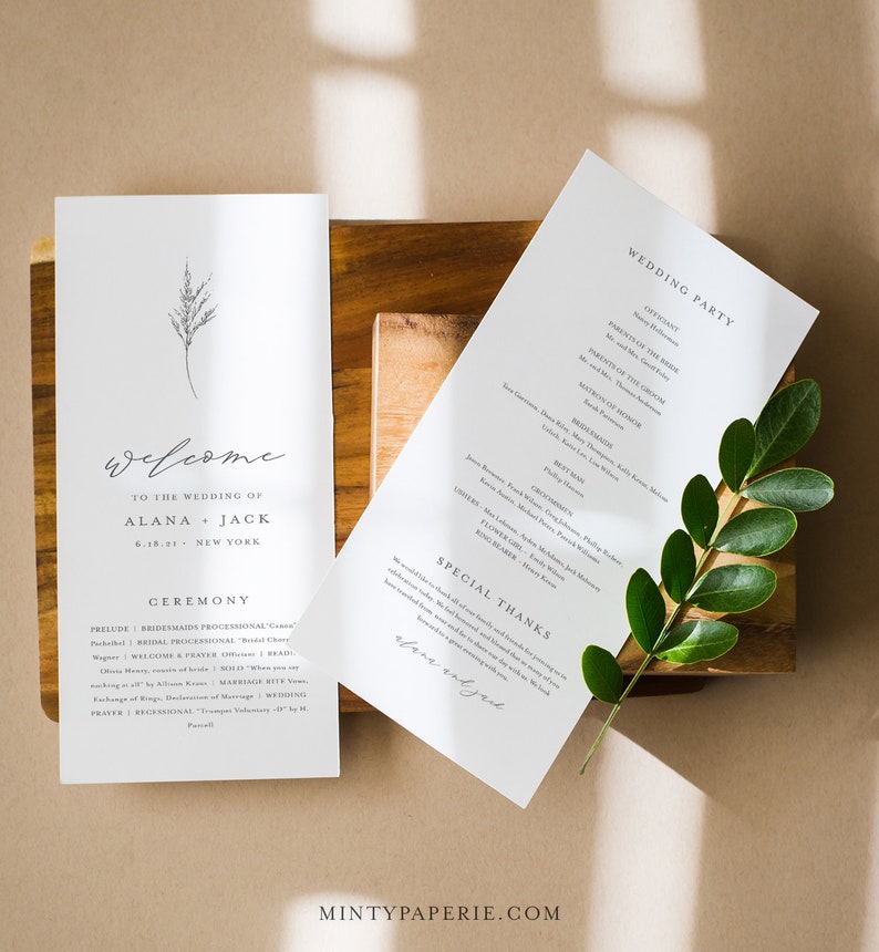 May include: A minimalist wedding ceremony program with a simple floral design. The program includes the wedding party, ceremony details, and a special thanks section. The text reads "Welcome to the wedding of Alana + Jack 6.18.21 New York".