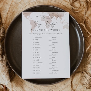 May include: A printable baby shower game card with a light brown watercolor background and a world map design. The card has the title "Say 'Baby' Around the World" and asks players to match the language with the correct translation of "baby".