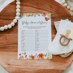 May include: A printable baby animal game with a floral design. The game features a list of 30 animals with blank lines for players to fill in the names of their babies. The text on the game says "Baby Animal Game" and "Fill in the blanks with the correct name of each animal's baby. Person with the most correct wins!"