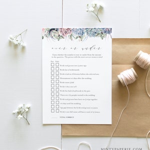 May include: A white card with a watercolor floral design at the top, featuring succulents in shades of blue, pink, and green. The card is a wedding game, with questions about the bride and groom. Two spools of pink thread and sprigs of white flowers are also in the image.