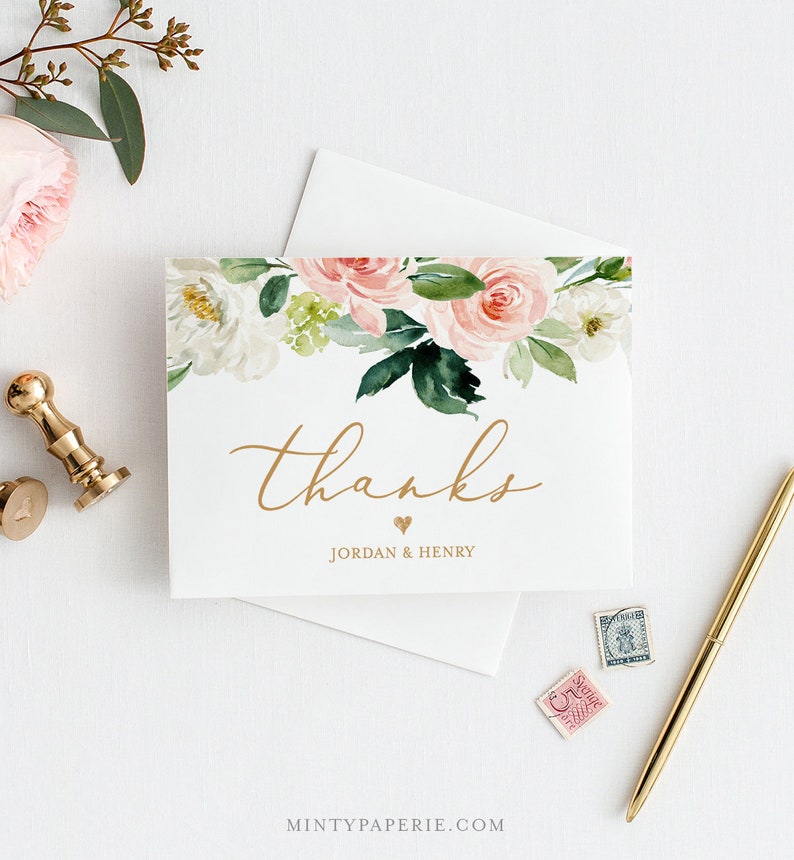 May include: A white thank you card with a floral design featuring pink and white roses, green leaves, and the word "thanks" in gold script. The names "Jordan & Henry" are below the word "thanks". A gold pen and wax seal are also visible.